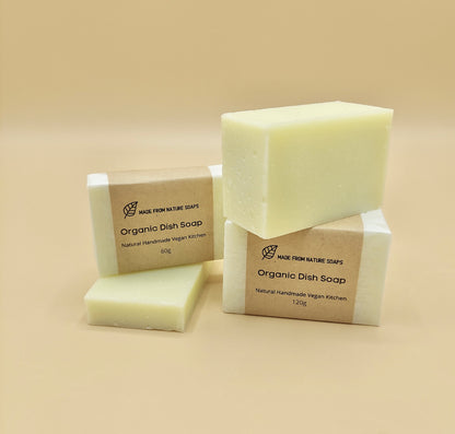 Two bars of organic dish soap with packaging on a beige background with label Organic Dish Soap. Organic Dish Soap bars are multipurpose, suitable for scrubbing pots, pans, and even cleaning countertops.