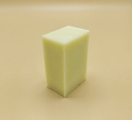 White rectangular bar of soap on a beige background. Organic kitchen dish soap bars offer a sustainable, non-toxic, and cost-effective alternative to liquid detergent.